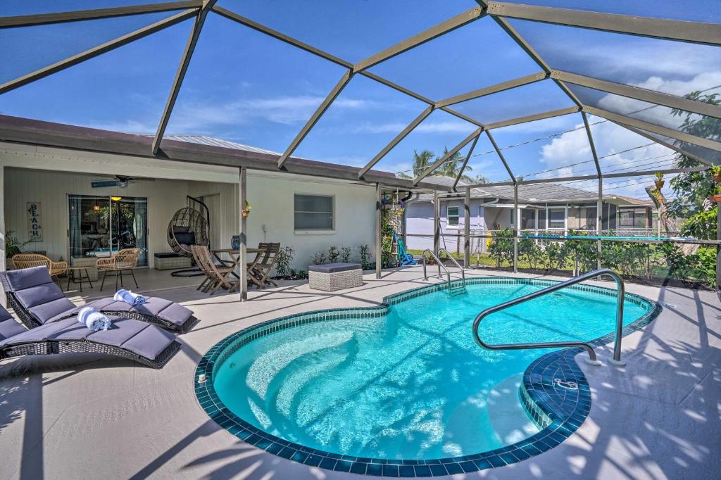 a swimming pool with a glass roof on a patio at Naples Oasis with Screened Pool, Bike to Beach! in Naples