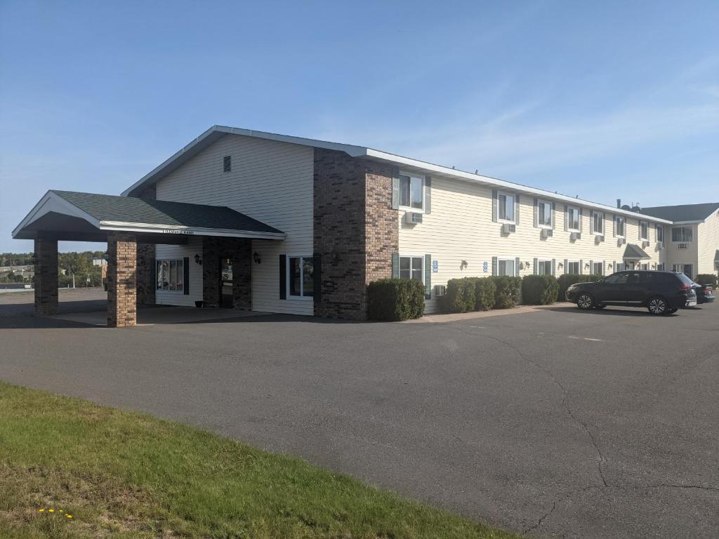 un bâtiment avec une voiture garée devant lui dans l'établissement Value Host Marquette, à Marquette