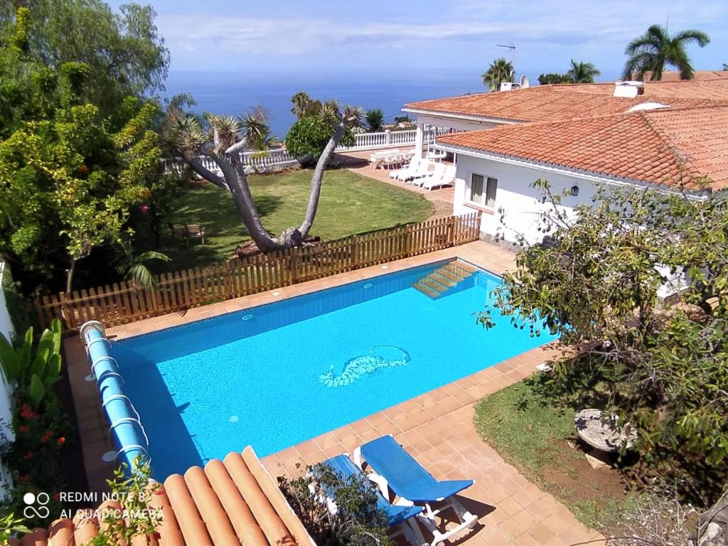 uma imagem de uma piscina em frente a uma casa em Villa Dragos em Santa Úrsula