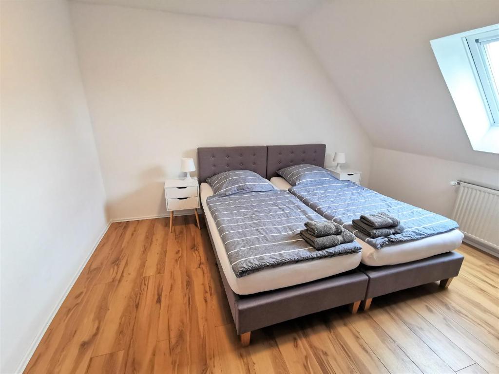 a bedroom with a bed and a wooden floor at Ferien in Sarstedt am Bruchgraben in Sarstedt
