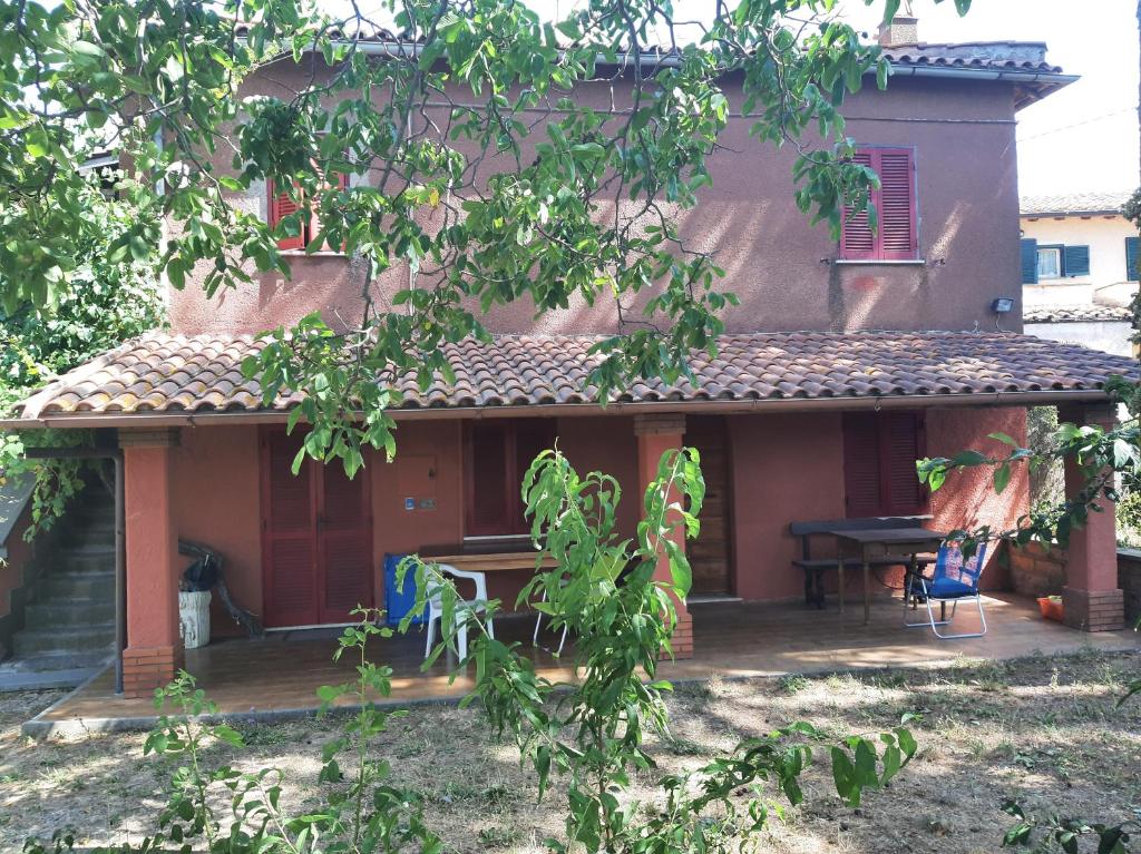 a house with a patio with a table and chairs at Tuscia Viterbese Casale Nel Verde in Viterbo