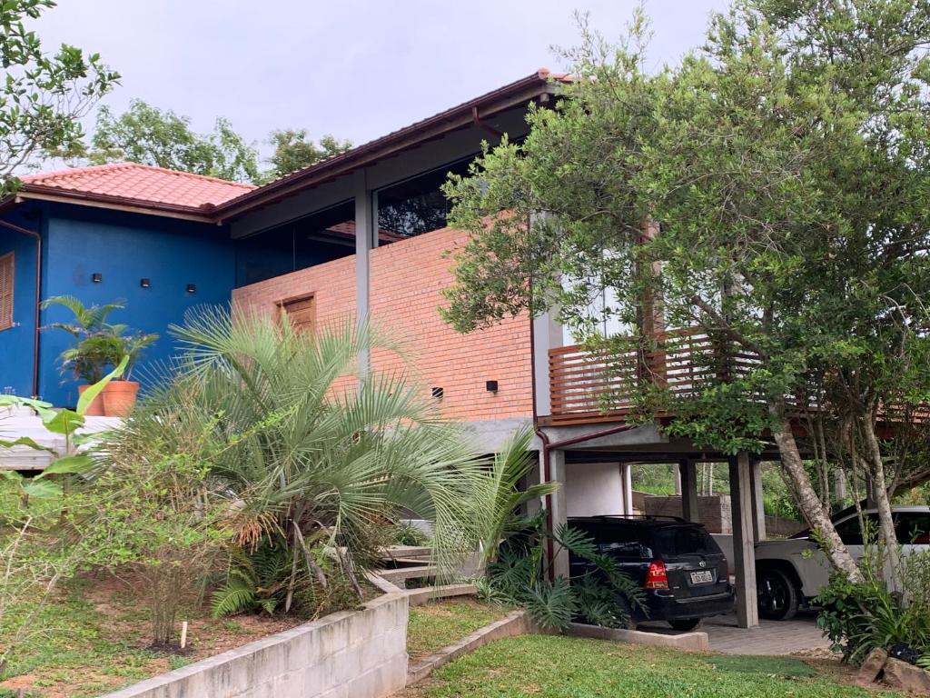 a house with a car parked in front of it at Magnífica casa no Rosa in Imbituba