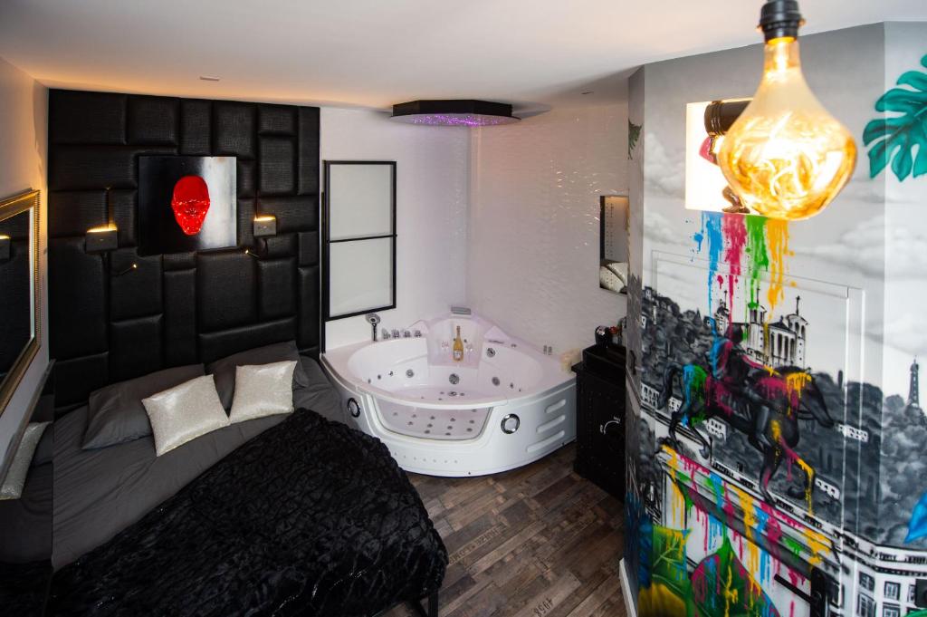 een badkamer met een groot bad en een groot raam bij URBAN JUNGLE SPA in Villeurbanne