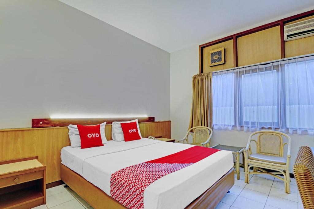 um quarto com uma cama, uma secretária e uma janela em Super OYO Flagship 90658 Hotel Asteria em Bandung