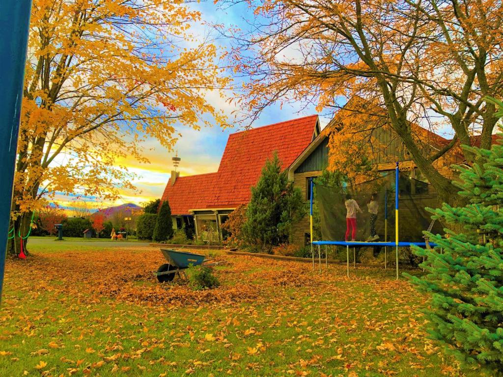 ein Haus in einem Hof mit Blättern auf dem Boden in der Unterkunft Motel Bonsoir in Granby