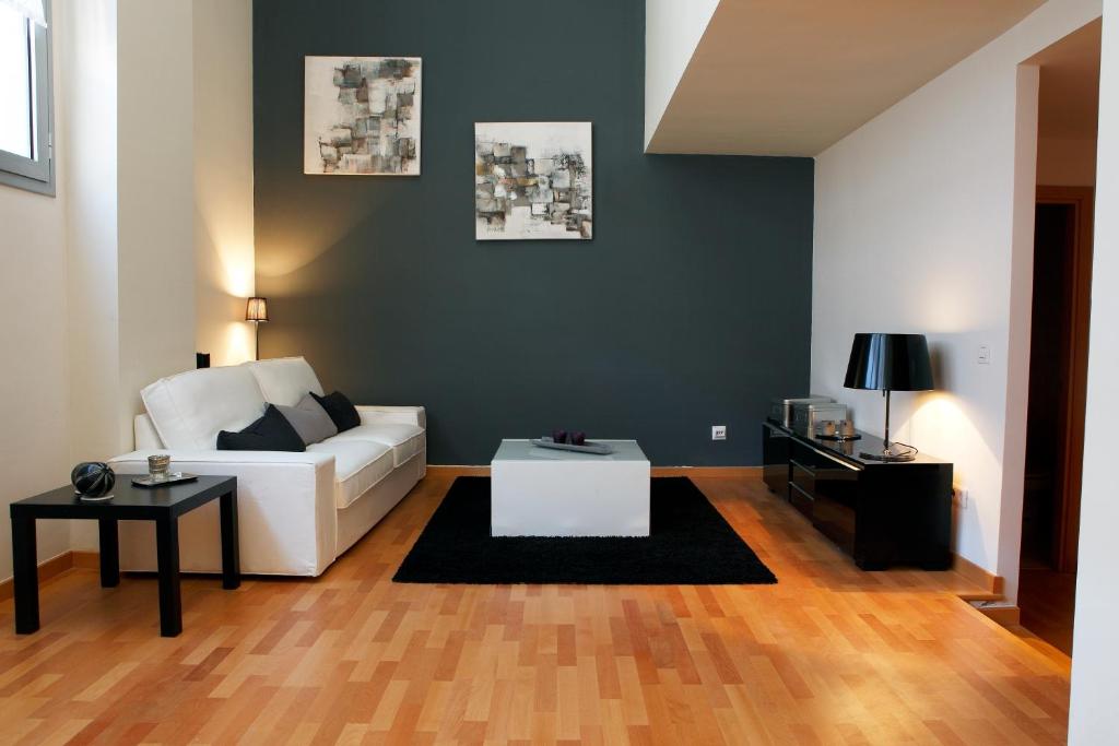 ein Wohnzimmer mit einem weißen Sofa und einem Tisch in der Unterkunft Fira Duplex in Hospitalet de Llobregat