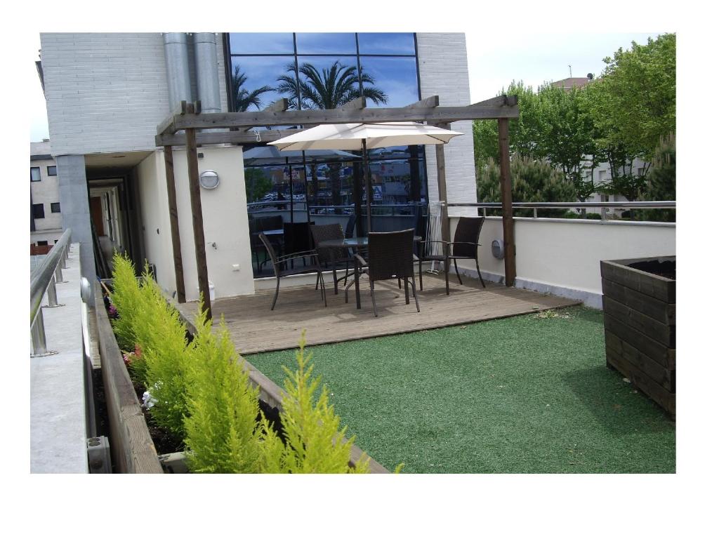 patio con mesa y sombrilla en el balcón en Port D'Aro, en Platja d'Aro