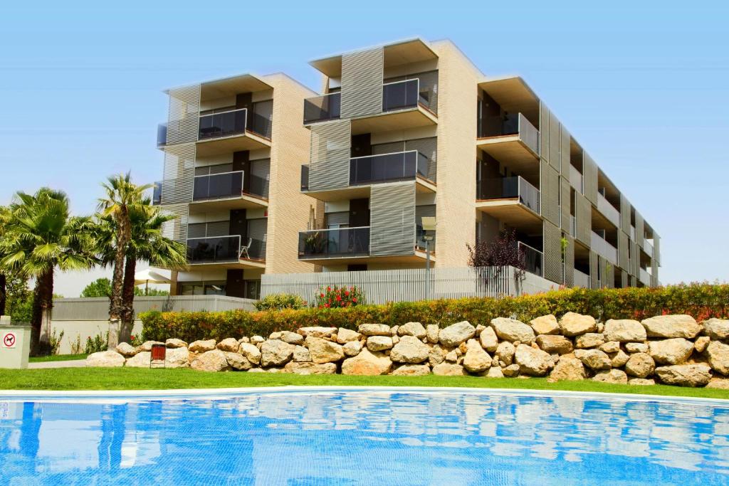 un immeuble d'appartements avec une piscine en face dans l'établissement Rentalmar Paradise Families Only con parking, à Salou