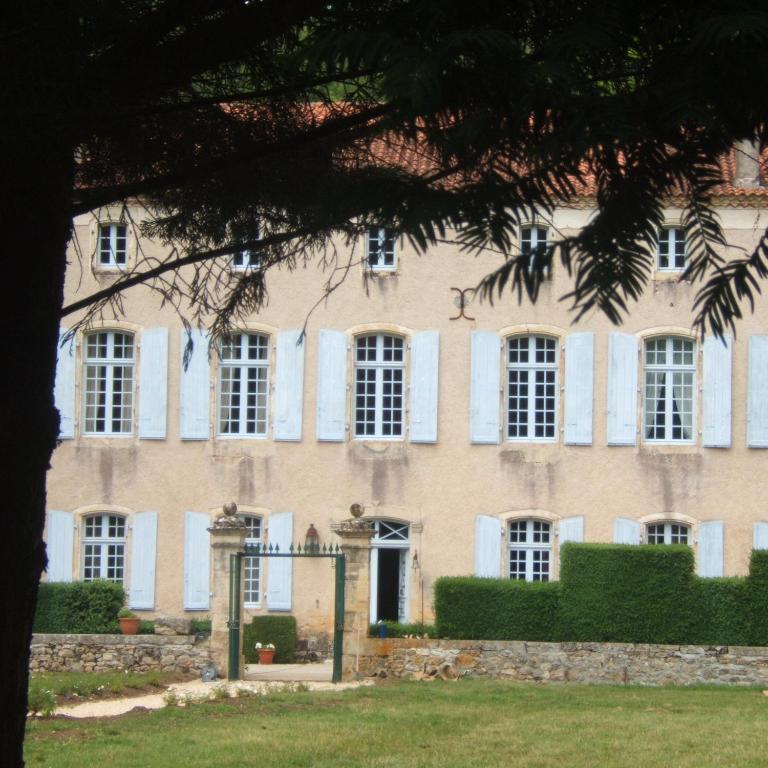 a large brick building with white windows at La Mouline in Labastide-du-Vert