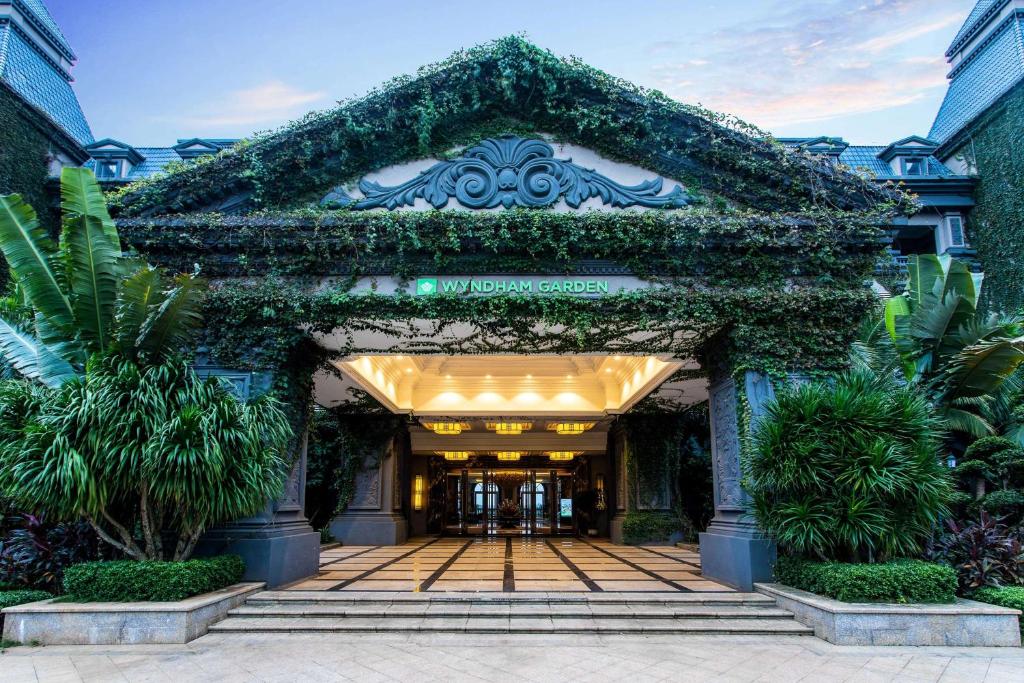 an entrance to a building covered in ivy at Wyndham Garden Haikou South in Haikou