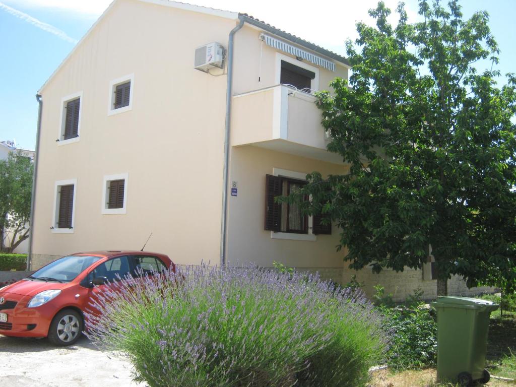 ein rotes Auto, das vor einem Gebäude parkt in der Unterkunft Apartments Blanka in Zadar