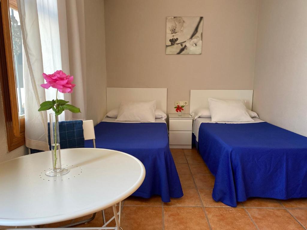 A bed or beds in a room at Hostal Moscatel