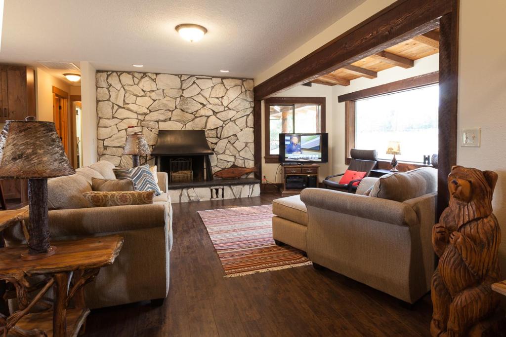 a living room with couches and a stone fireplace at Hood View 30 Day Minimum cabin in Mount Hood