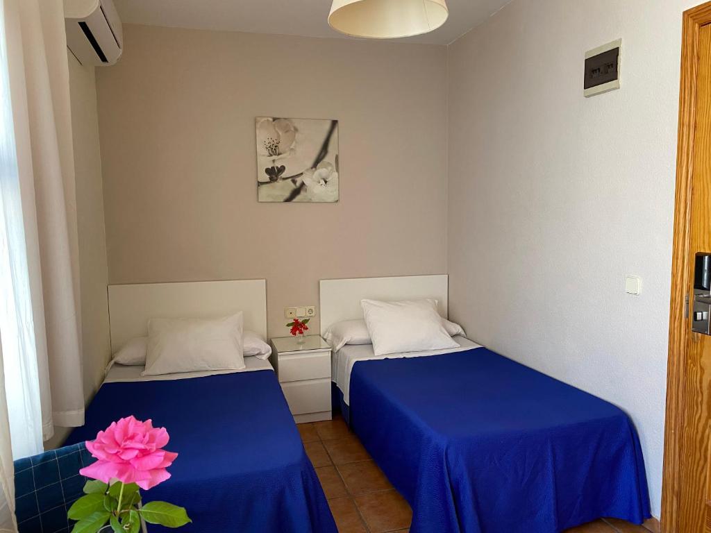 A bed or beds in a room at Hostal Moscatel