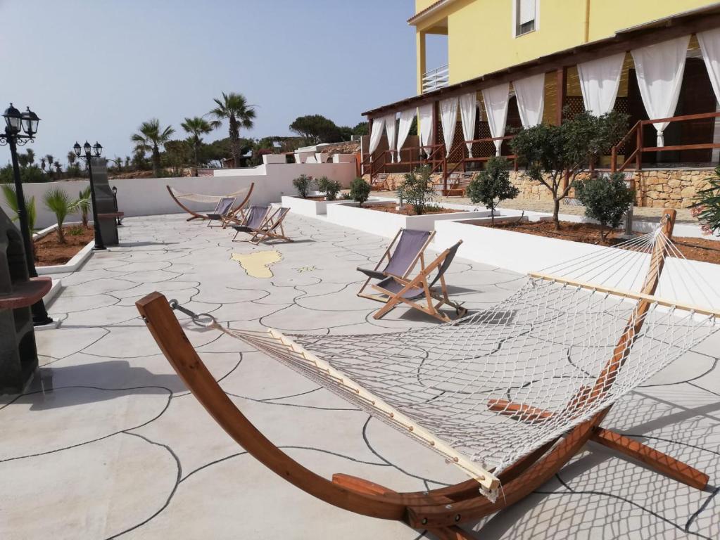 eine Hängematte auf einer Terrasse in einem Resort in der Unterkunft CASE VACANZE I QUATTROVENTI in Lampedusa