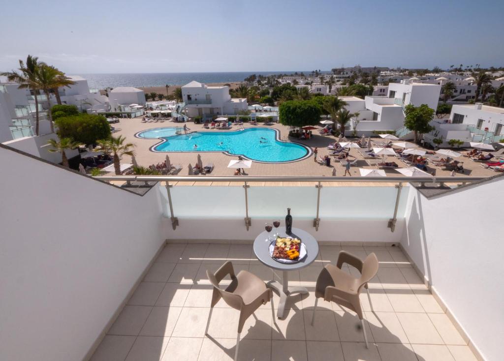 a view of the pool from the balcony of a resort at Hotel Lanzarote Village in Puerto del Carmen