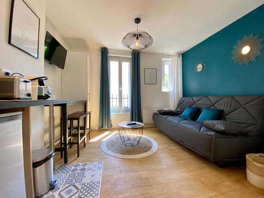 ein Wohnzimmer mit einem Sofa und einem Tisch in der Unterkunft Studios Sauzède - Carcassonne centre-ville in Carcassonne