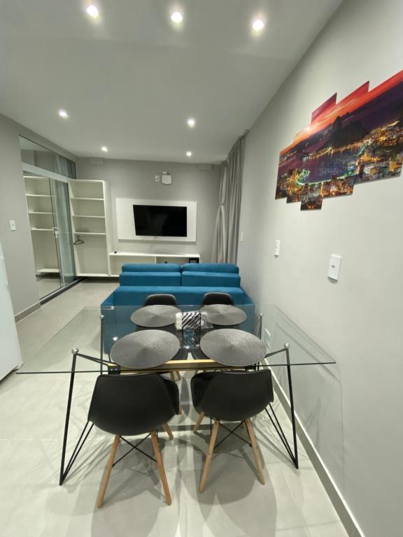 ein Esszimmer mit einem Tisch und einem blauen Sofa in der Unterkunft Waikiki Apartament Ipanema in Rio de Janeiro