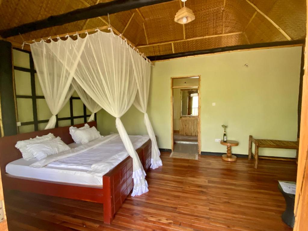 a bedroom with a bed with a mosquito net at Enshama Game Lodge and Campsite in Katunguru