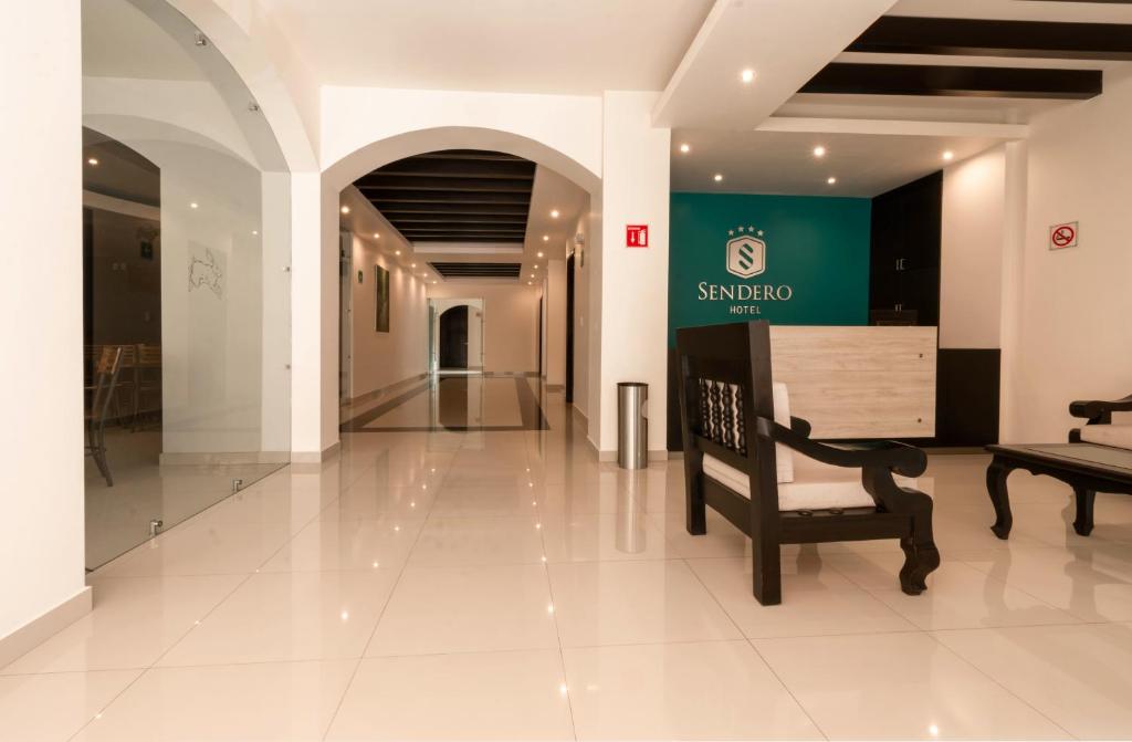 een lobby met een stoel en een bord in een gebouw bij Sendero Hotel in Actopan