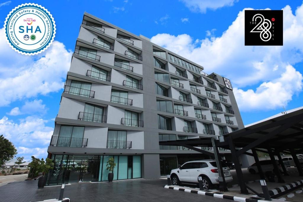 a white car parked in front of a building at The 28th Hotel in Kanchanaburi