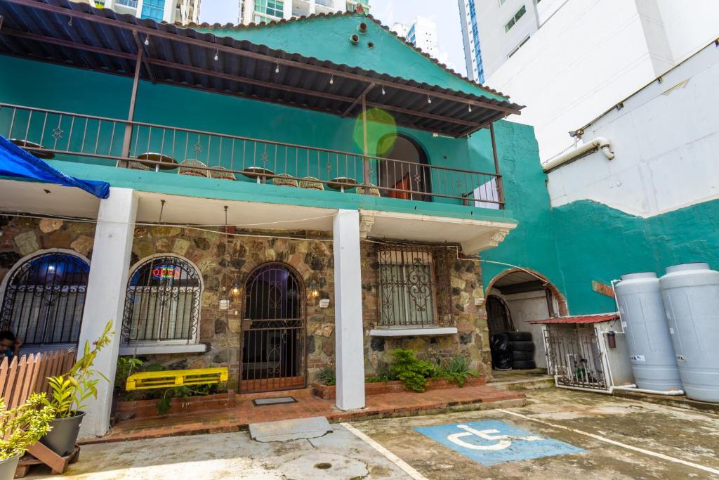 ein grünes Gebäude mit Balkon darüber in der Unterkunft Hostel the pod 33 in Panama-Stadt