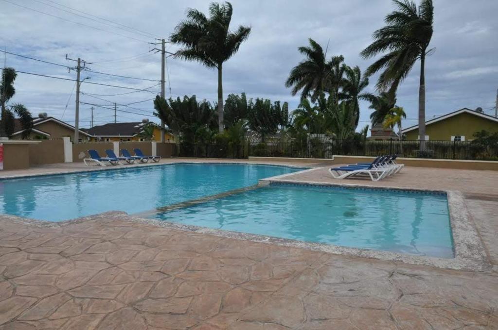 una gran piscina con sillas y palmeras en Epic Paradise en Ocho Rios
