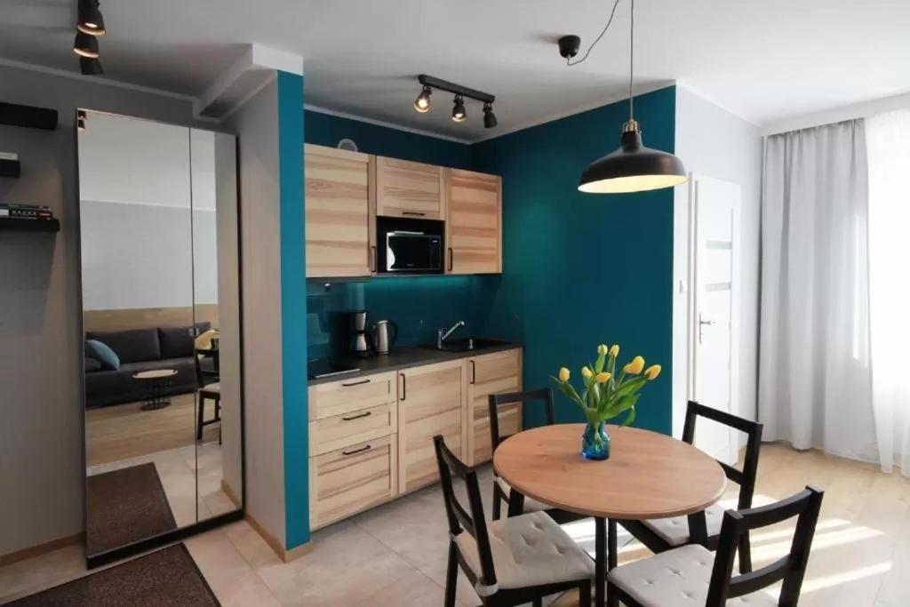 a kitchen and dining room with a table and chairs at Studio Four Seasons with parking place in Gdańsk