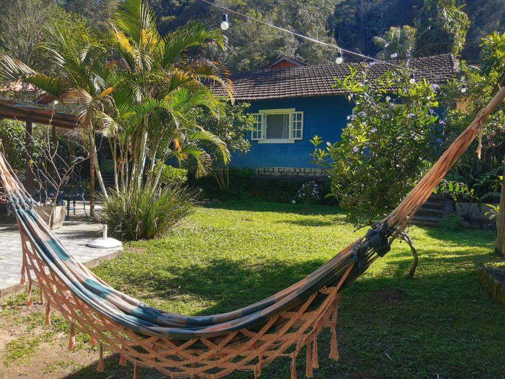 a hammock in a yard in front of a house at Pousada Casa Azul in Lumiar