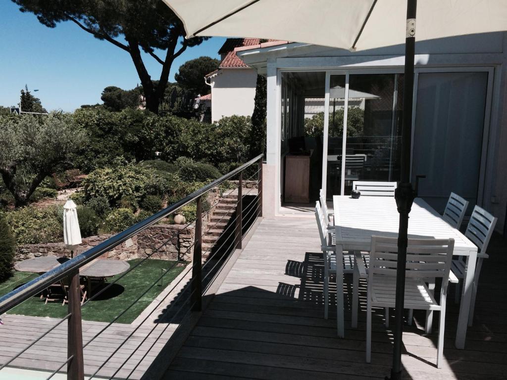 a porch with a table and chairs and an umbrella at Hotel Villa Maya in Saint-Tropez