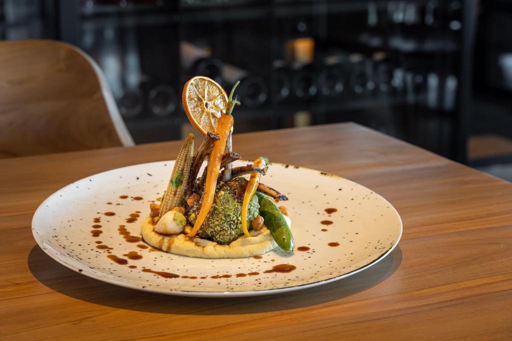 a plate of food with vegetables on a table at 3HB Faro in Faro