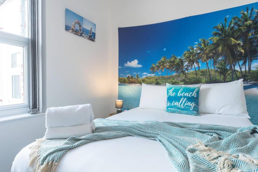 una camera con un letto e una foto dell'oceano di WGcDDE Large 3 Bedroom House - Parking - Garden a Hull