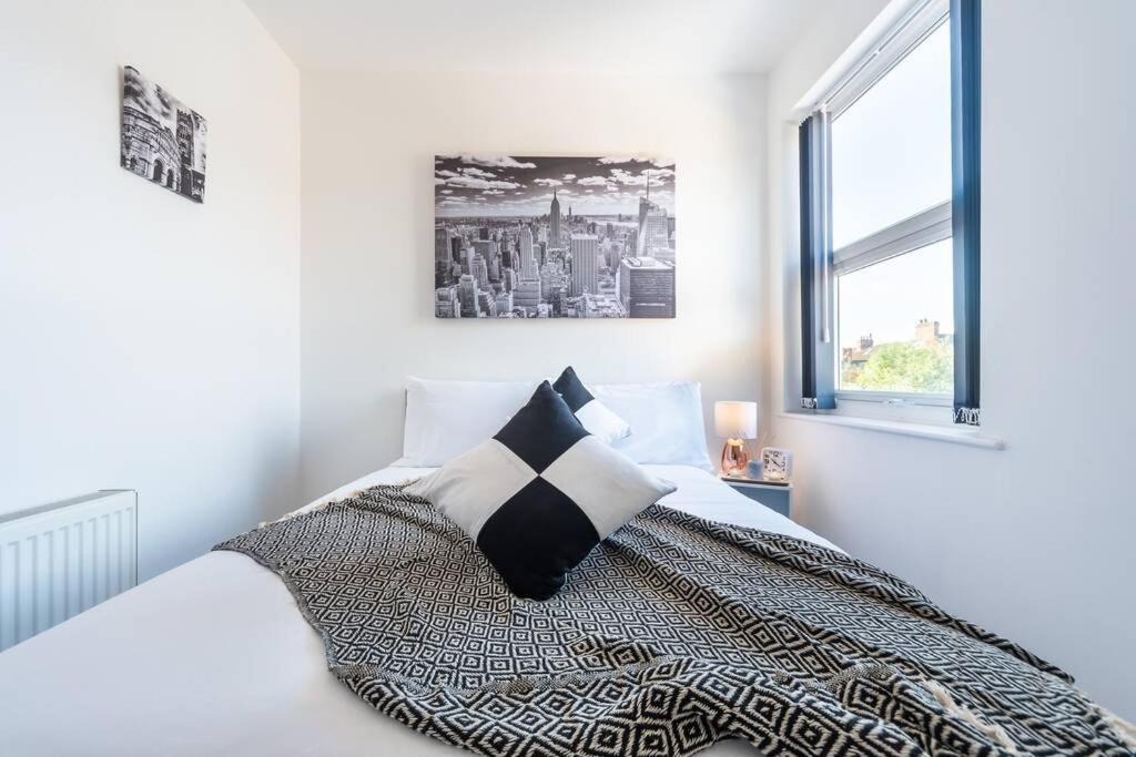 a white bedroom with a bed with a black and white pillow at WGcDDE Large 3 Bedroom House - Close to MKM Stadium & A63 - Garden in Hull