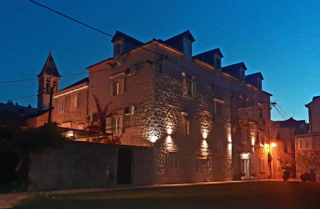 a large building with lights on the side of it at Carol Rooms in Trogir