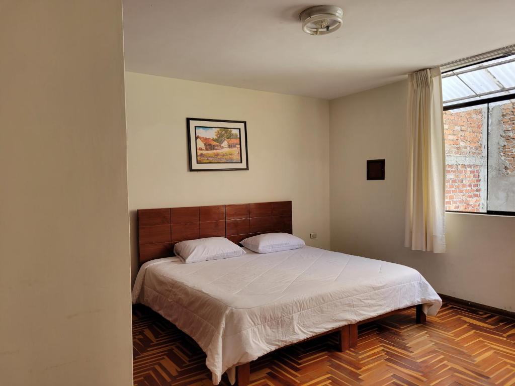 1 dormitorio con cama y ventana en Departamento Los Sauces, en Cajamarca