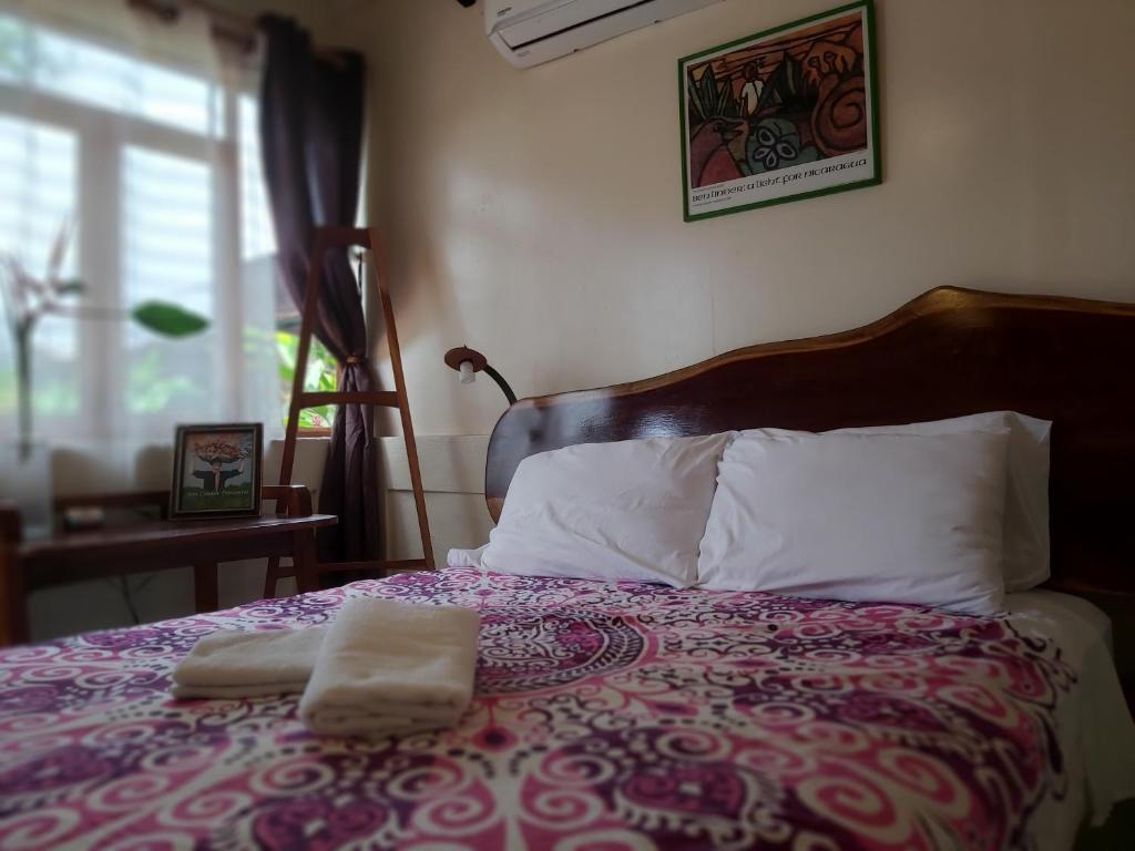 a bedroom with a bed with two towels on it at Casa Benjamin Linder in Managua
