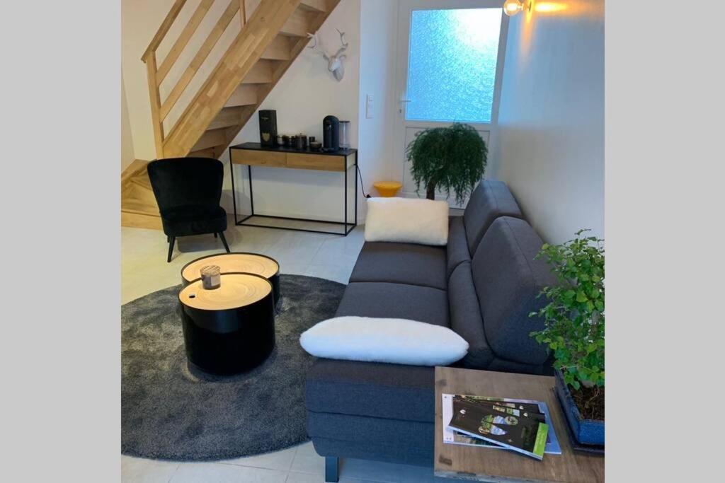 uma sala de estar com um sofá e uma mesa em Maisonnette au coeur du vignoble d'Hautvillers em Hautvillers
