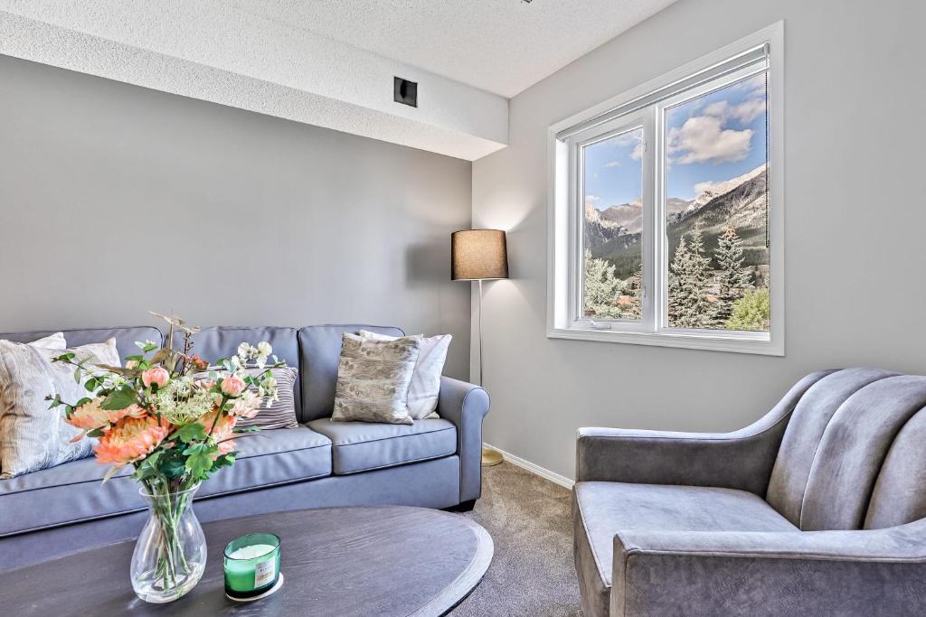 a living room with a couch and a vase of flowers at The Alfar by Samsara Resort Private Entry Panorama Top View 3BR 2TH in Canmore