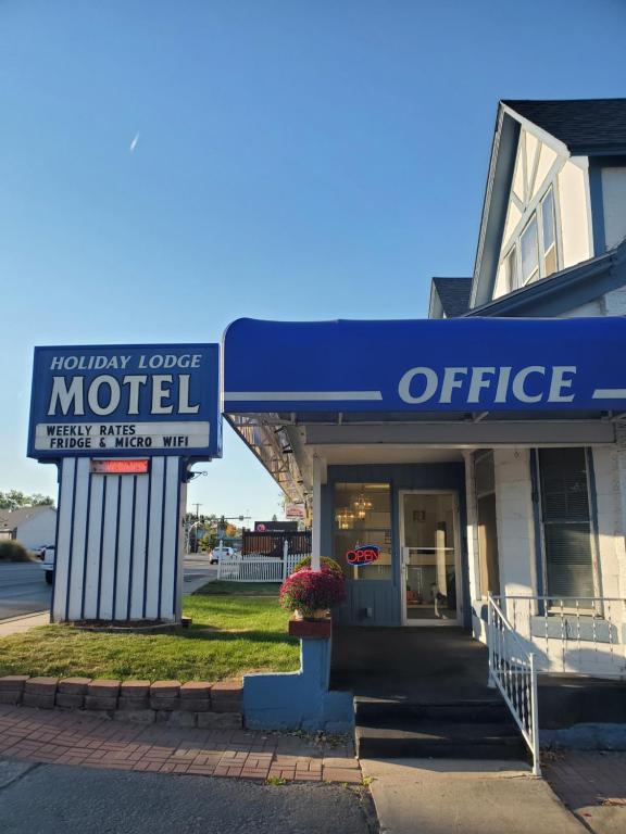 ein Bürogebäude mit einem Schild für ein Motel in der Unterkunft Holiday Lodge in Sheridan