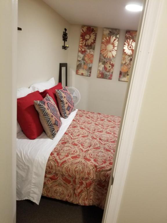 1 dormitorio con 1 cama con almohadas rojas en The Airport Lodge, en Collingdale