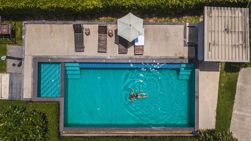 an overhead view of a person swimming in a swimming pool at Wanpratheep Village Kohphangan in Ban Madua Wan