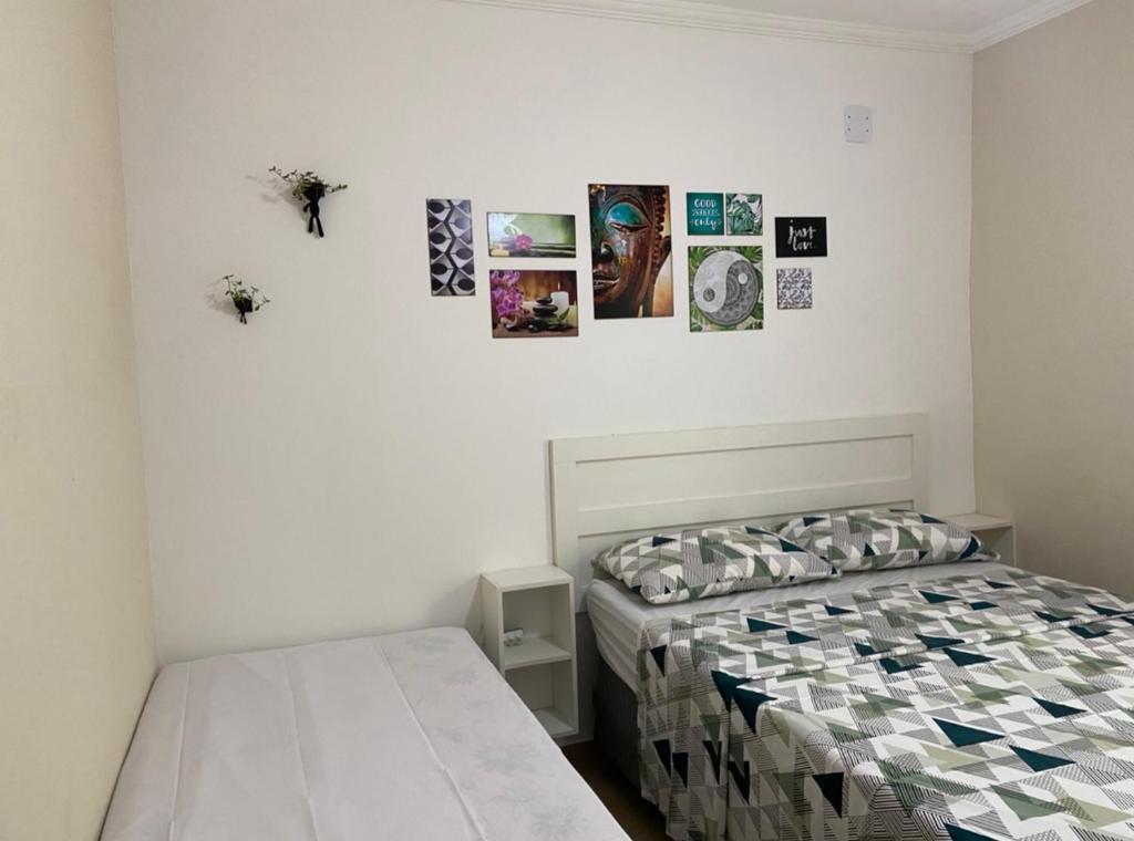 um quarto com duas camas e quadros na parede em Apês do Peró - Centro - suíte 03 em Cabo Frio