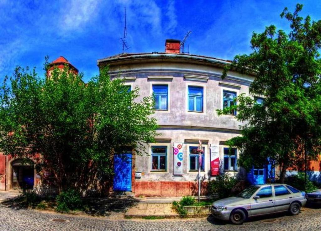 an old house with a car parked in front of it at Kaleidoszkóp Ház Hostel in Esztergom