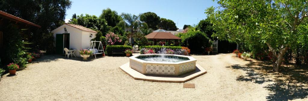 a garden with a fountain in the middle of a yard at Residenza Villa I Nidi in Santa Caterina di Nardò