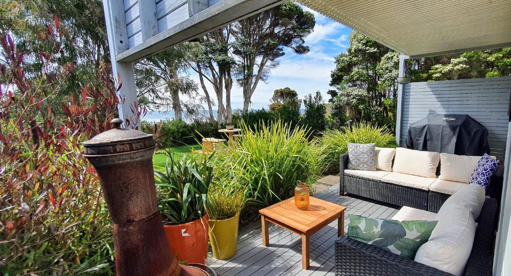 a porch with a couch and a coffee table at Goat Island Bungalow in Ulverstone