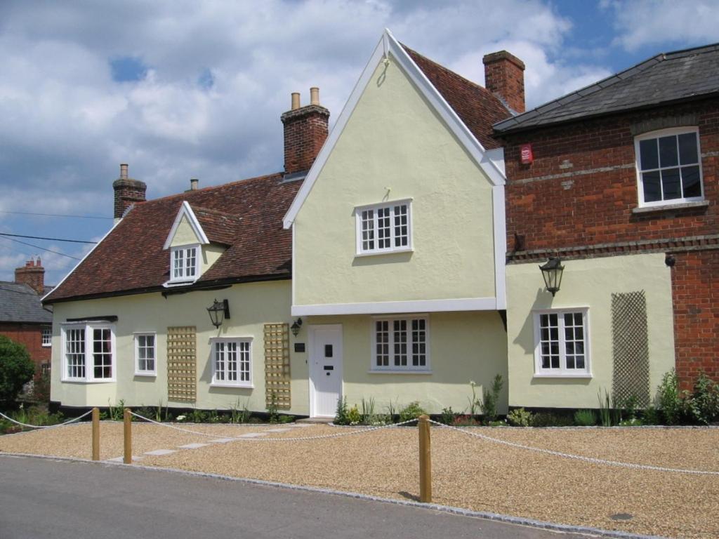 a white house with white windows on a street at Serenity House in Glemsford