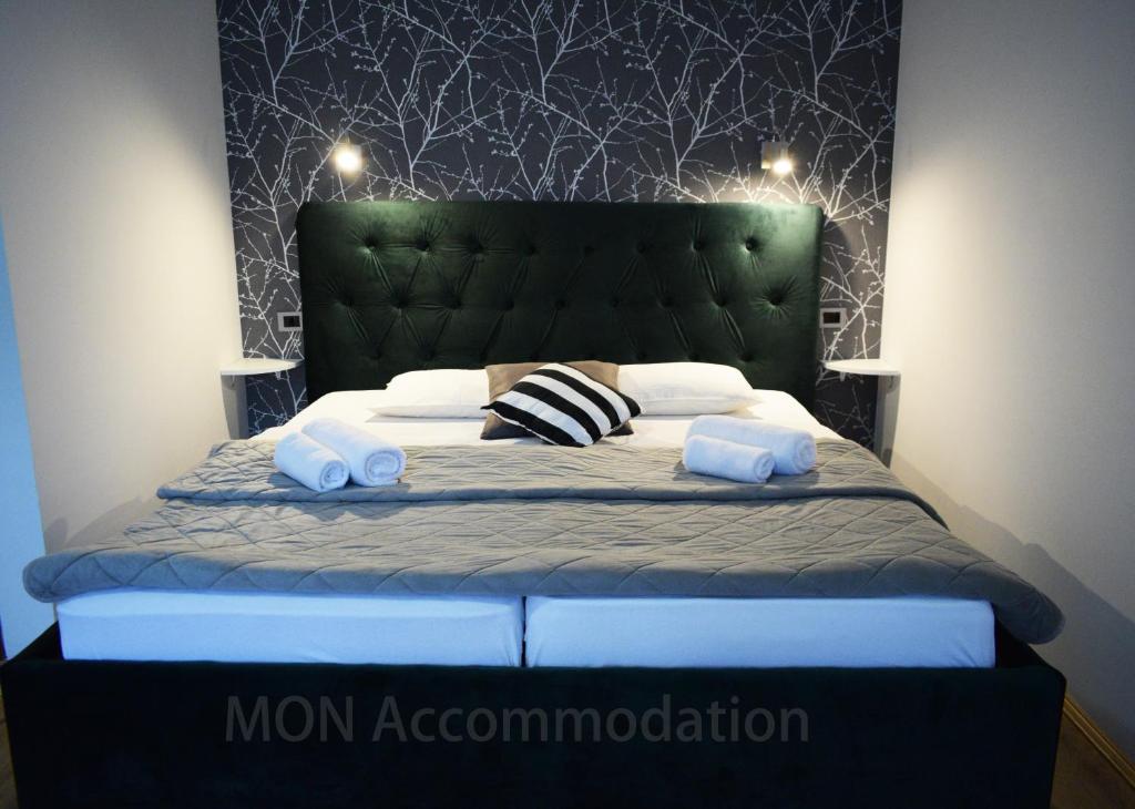 a bedroom with a bed with a green headboard at MON Accommodation free parking in Niš