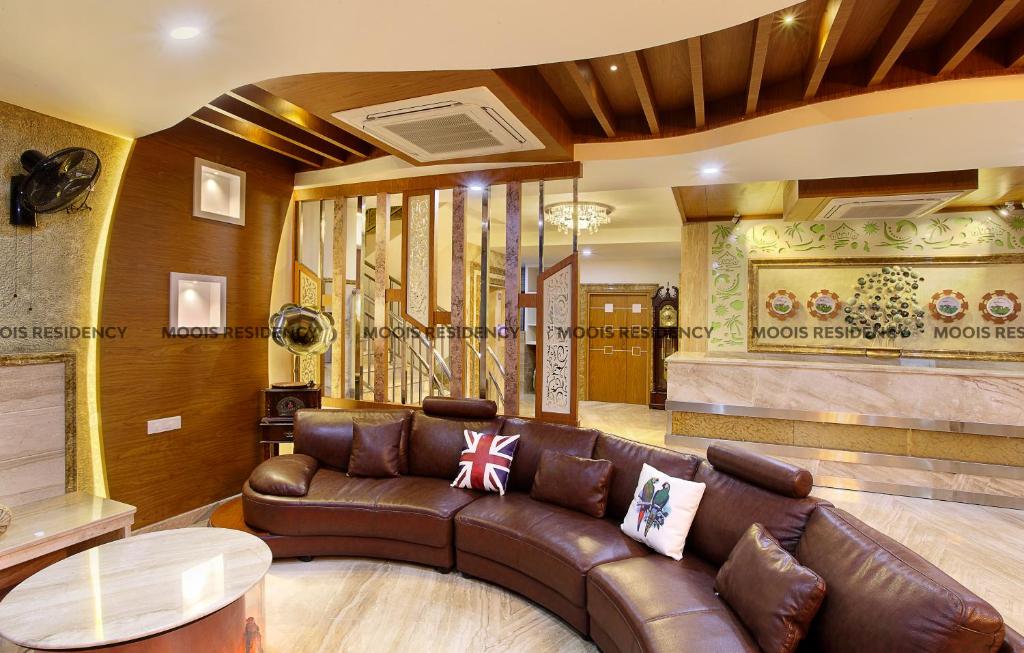 a living room with a leather couch and a table at Moois Residency in Kannur