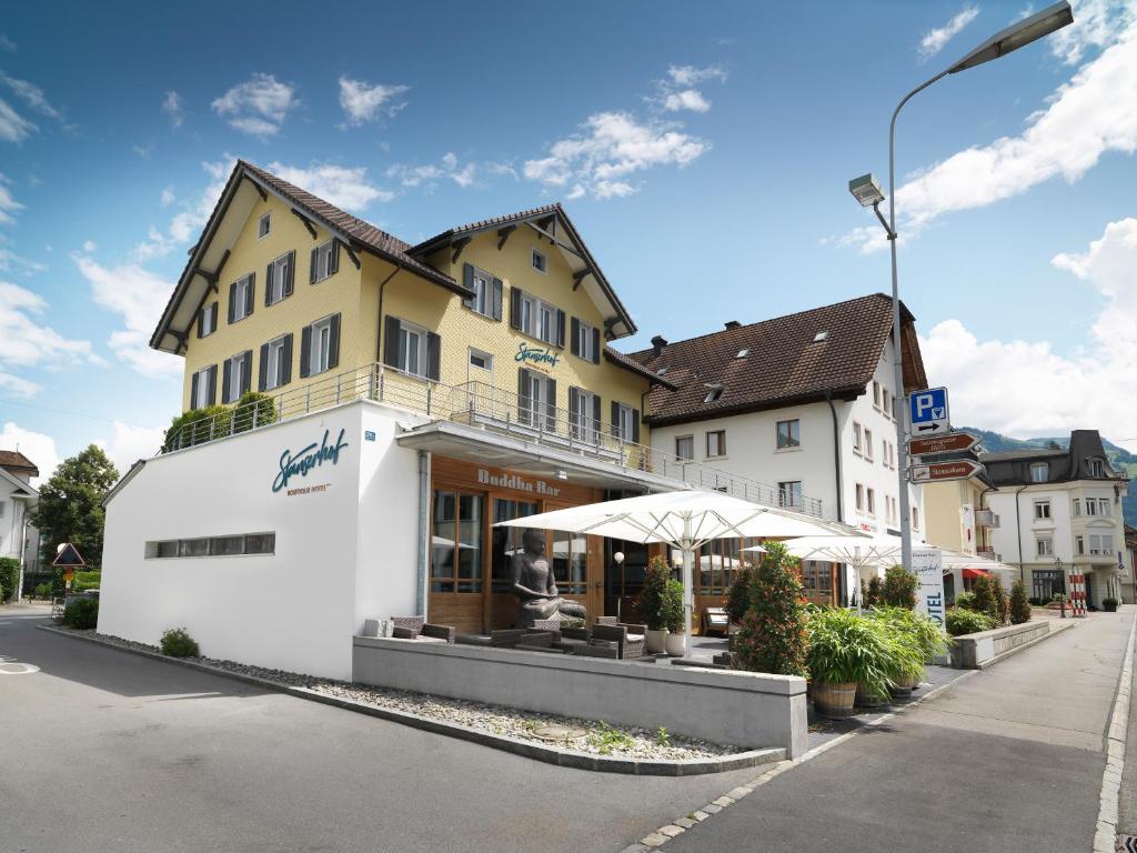 a white building with an umbrella in a street at Boutique Hotel Stanserhof in Stans