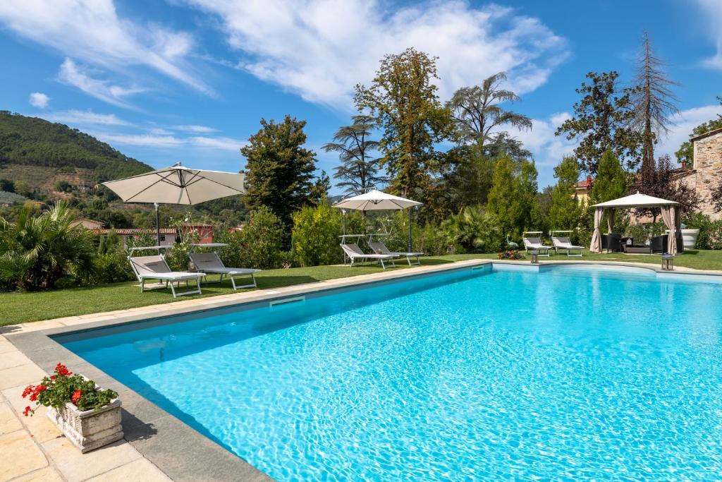 - une piscine avec des chaises et des parasols dans la cour dans l'établissement Villa Brancoli, à Capannori